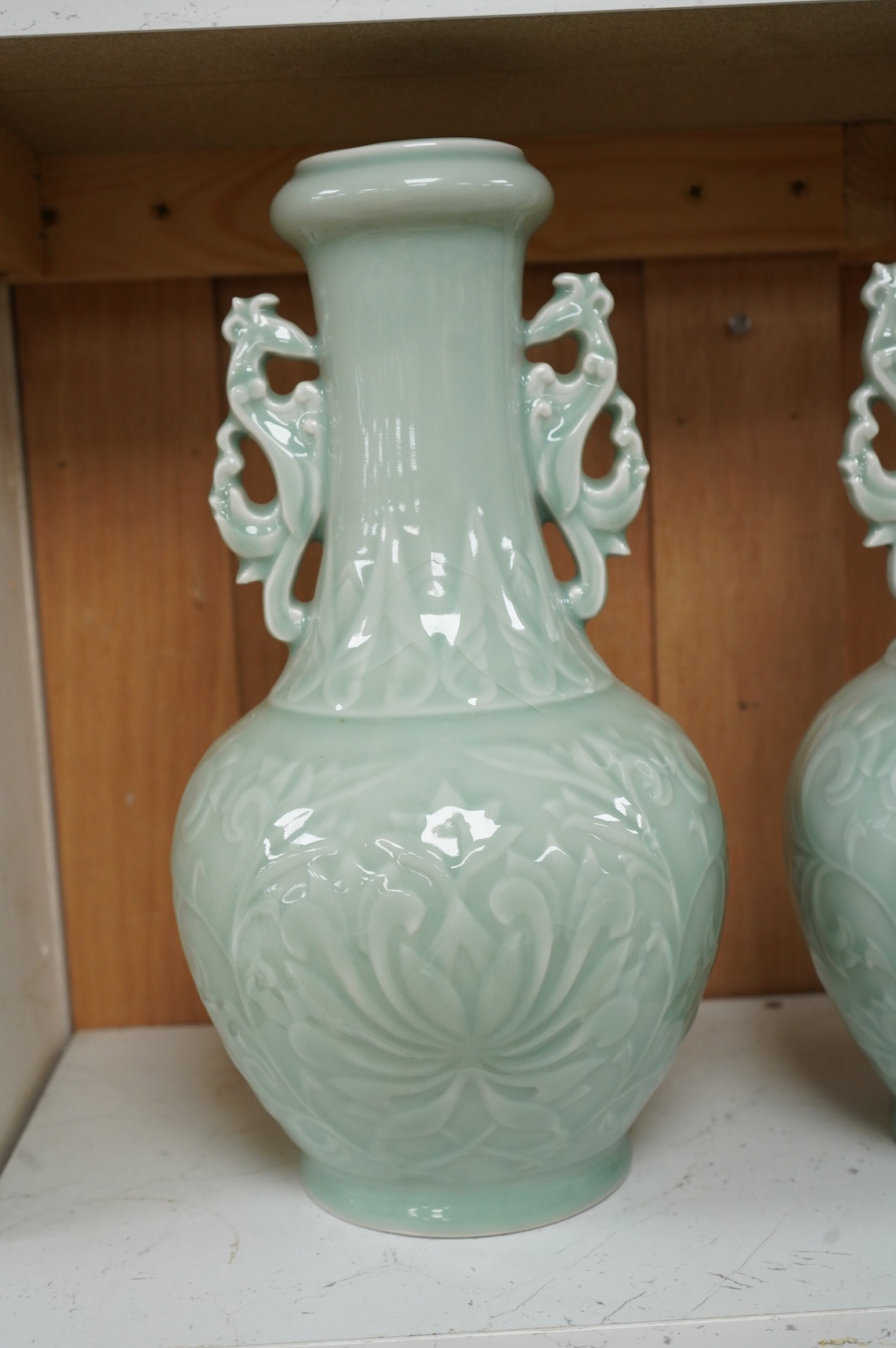 A pair of Chinese celadon glazed vases, decorated in low relief, 32cm high